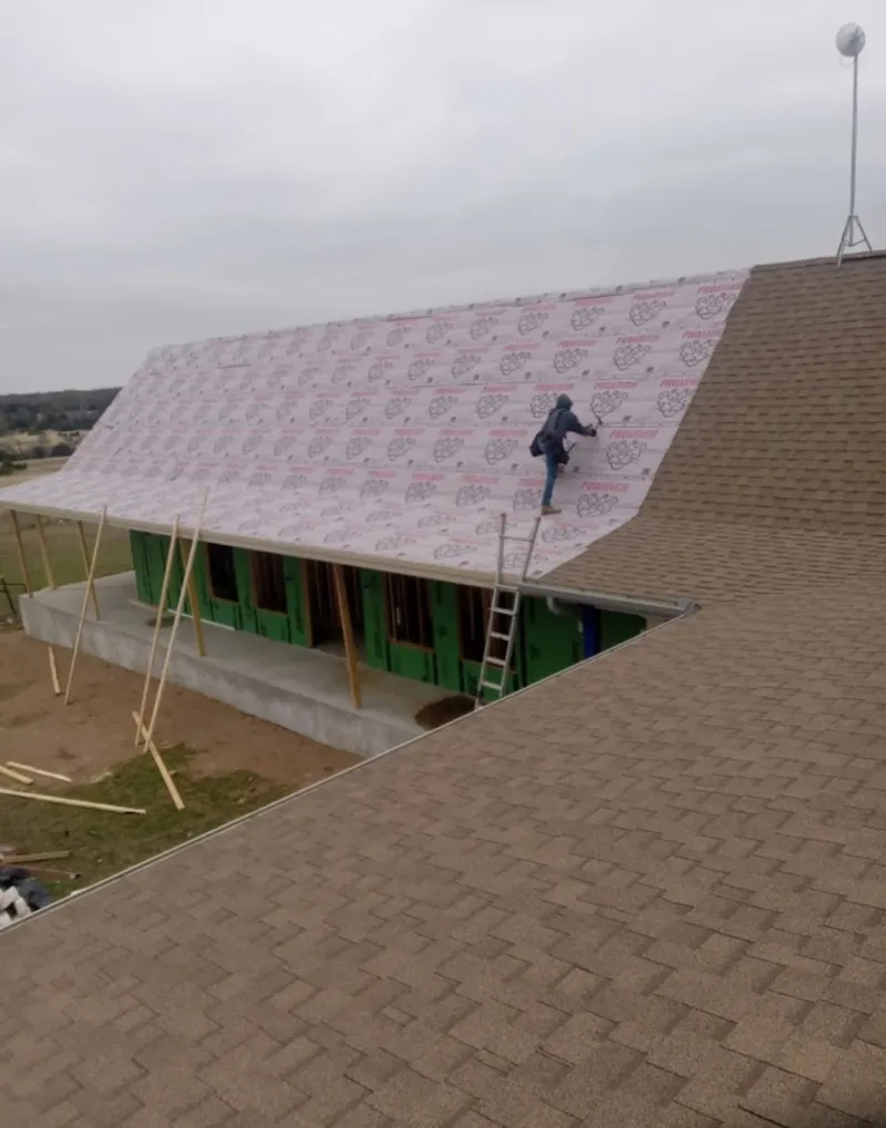 Worker preparing underlayment for a metal roof installation in Orcutt